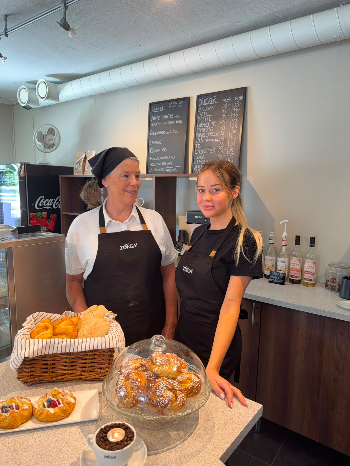 Mamma och dotter i Café Källarens bageri med nybakade bullar och wienerbröd